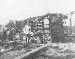 Żołnierz niemiecki przy zniszczonym wagonie kolejowym, b.d.m. [ze zbiorów IPN].