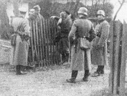 Niemcy wypytujący chłopów przy zagrodzie, b.d.m. [ze zbiorów IPN].