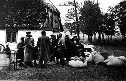 W oczekiwaniu na wysiedlenie. Polacy przed swoimi zabudowaniami zajętymi przez Niemców, b.d.m. [ze zbiorów IPN]